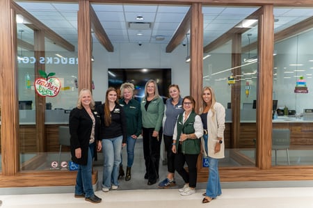 7 credit union employees standing outside of a branch.