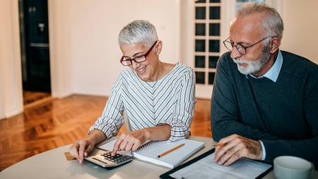 A mature couple reviewing their finances at a table