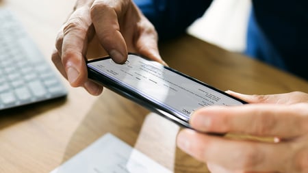 Man snapping a photo of a check to deposit with his banking app