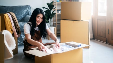 A young woman unpacking as she moves into her new home