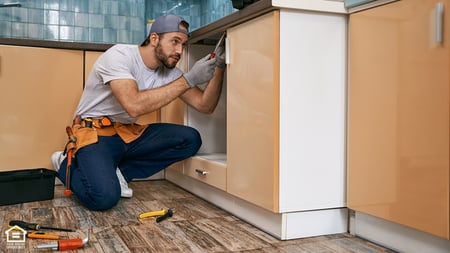 A contractor working on a cabinet. 
