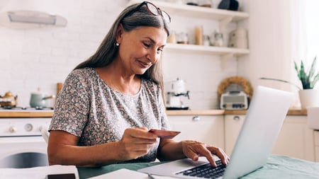 A women typing in her credit card information on a webpage. 