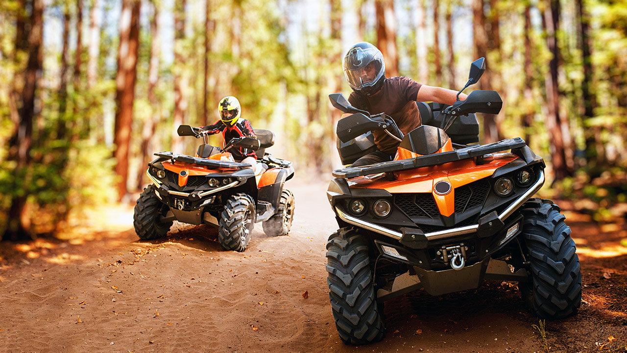 Two people riding ATVs