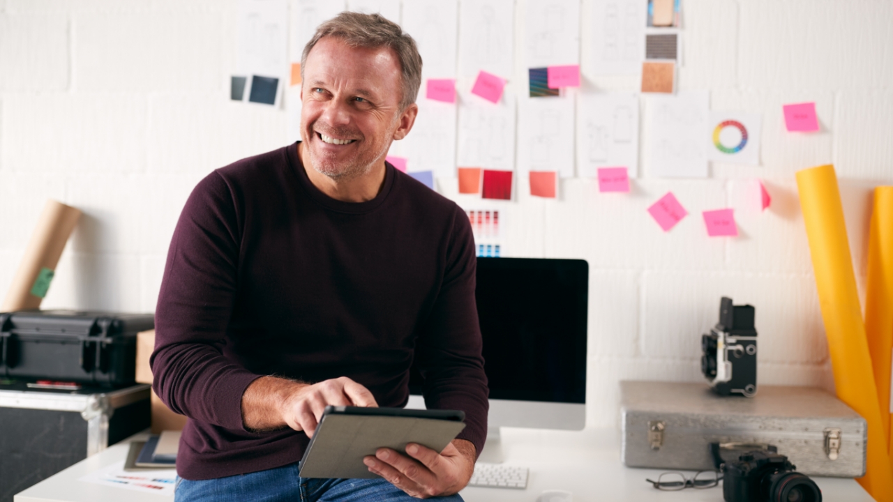 Smiling man using a tablet.